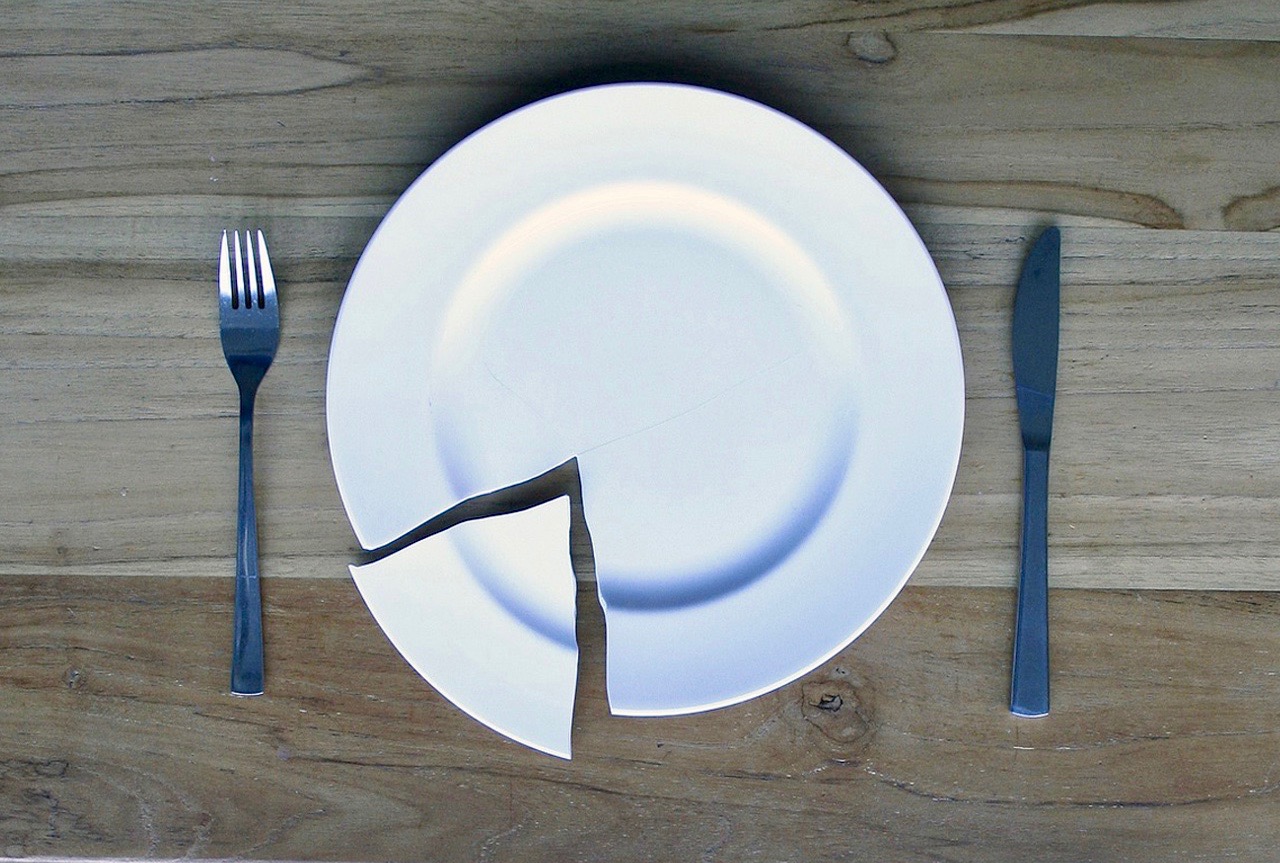broken white plate with fork and knife