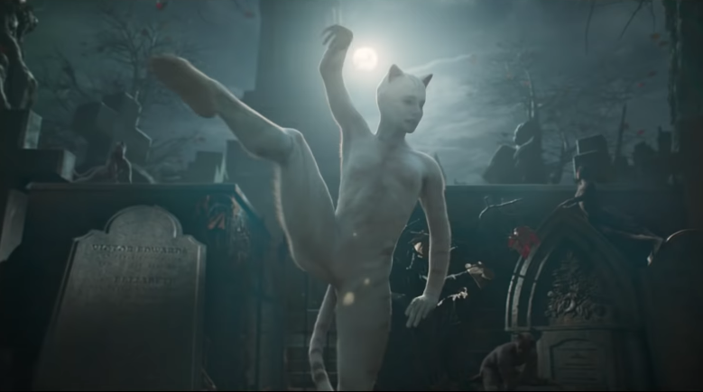 A humanoid cat does ballet in a graveyard. It is horrible.