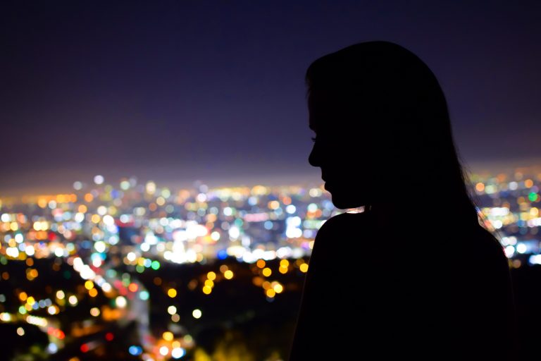 Woman in silhouette overlooking city