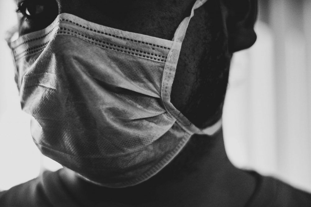 Black and white photo of man in surgical mask