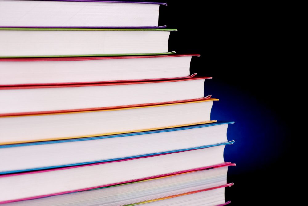 Stack of rainbow books on a black background