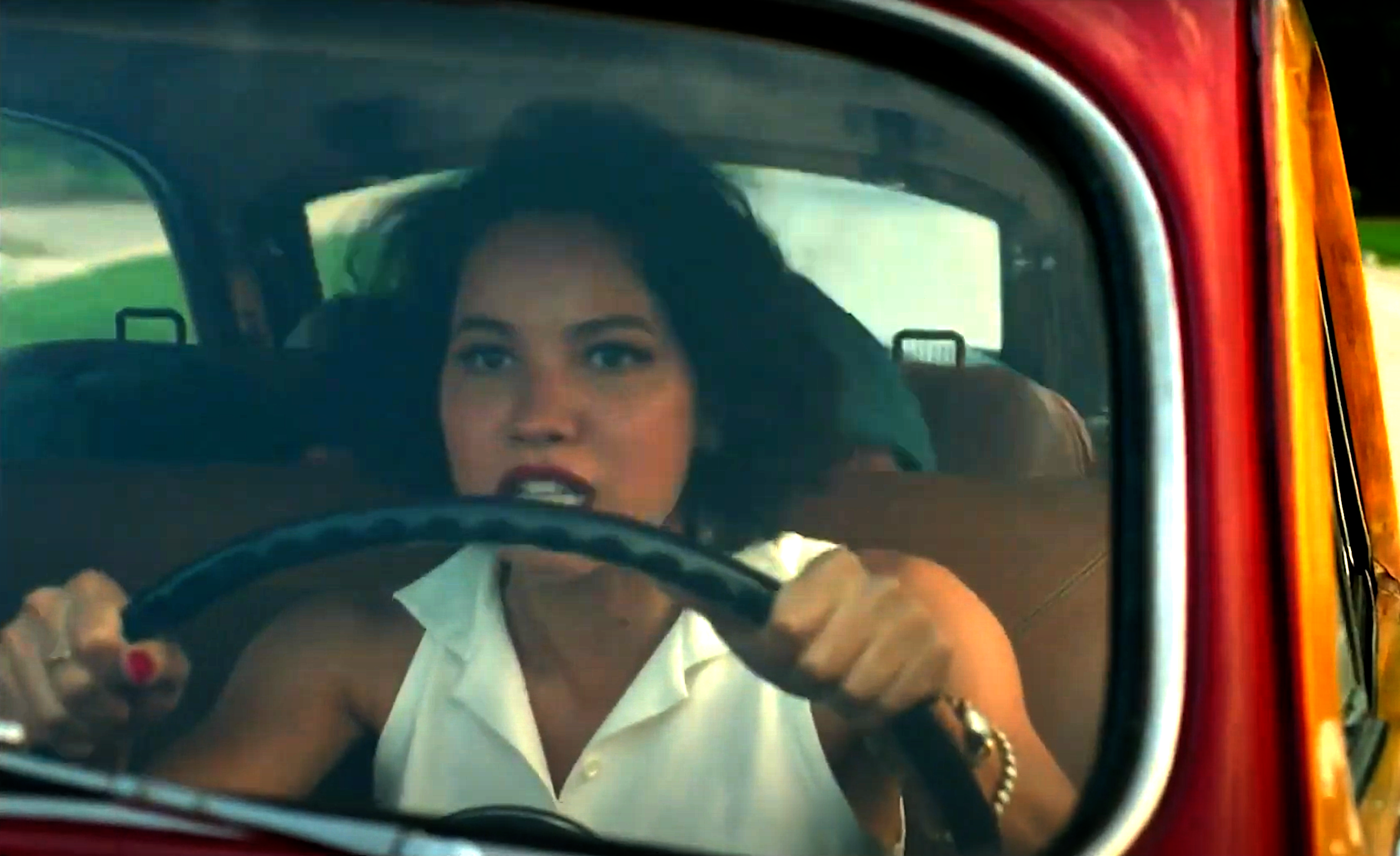 Jurnee Smollett looking very focused and tense, driving an old-fashioned car