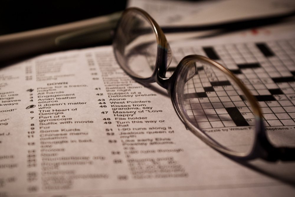 Pair of glasses sitting on a crossword puzzle