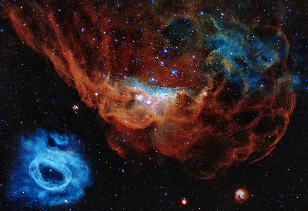 Hubble image of large red nebula and small blue nebula