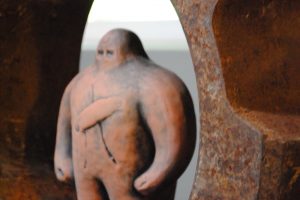 Golem figurine, a terra cotta-colored bulky humanoid figure with very little definition except for two eyes on its nub head