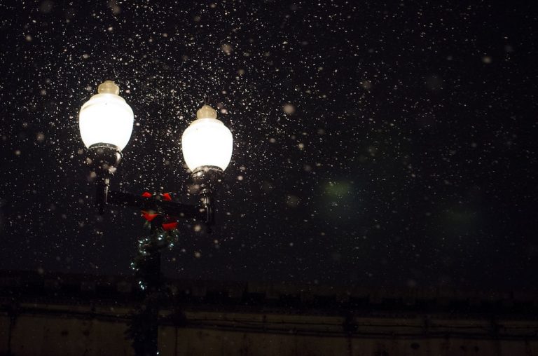 Image of a lamppost at night with snow and wreaths