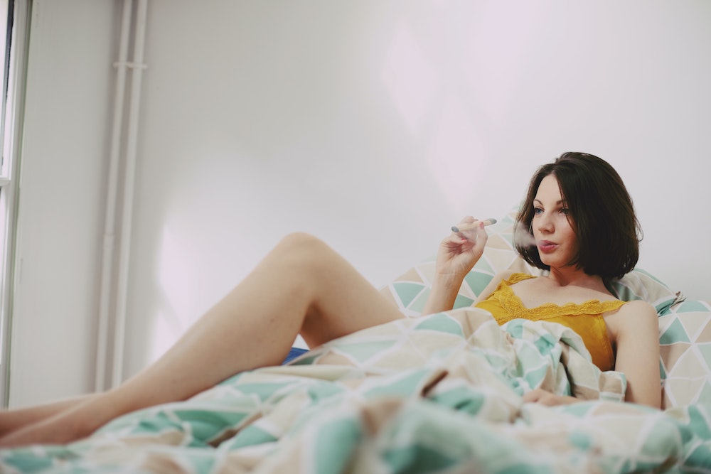 Image of woman smoking in bed