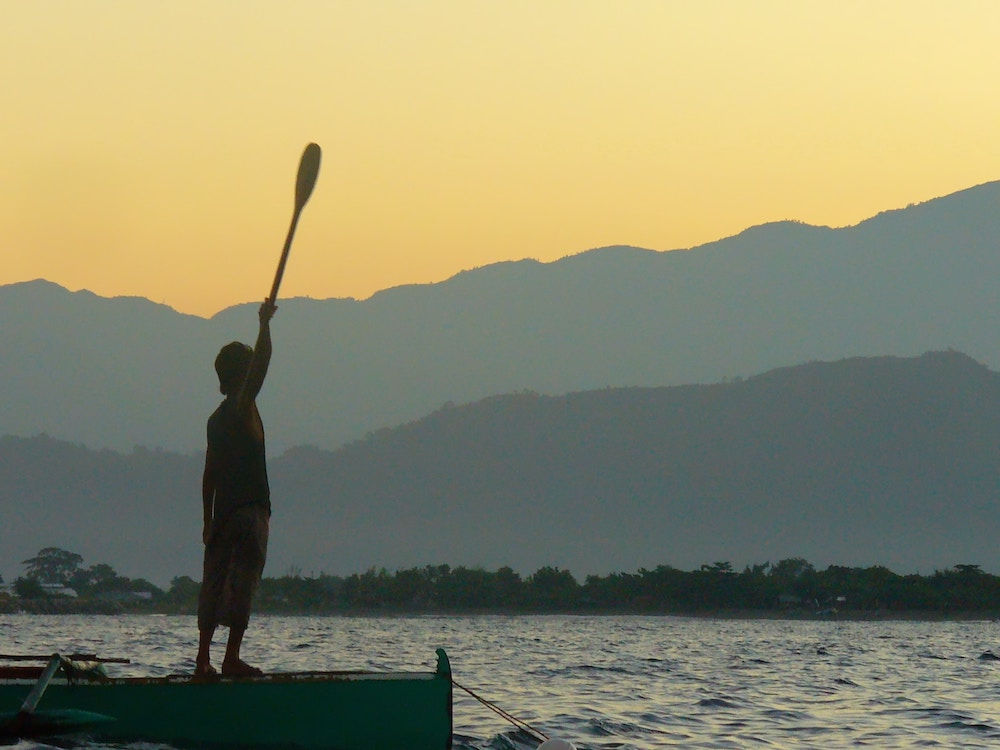 Fisherman holding paddle.