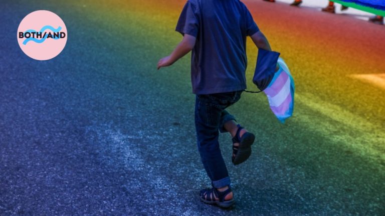 Child skipping in streets and holding a trans flag