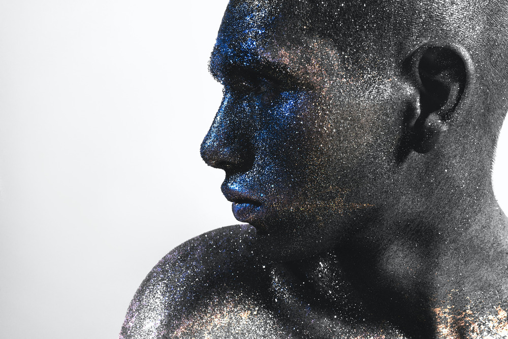 A man's face covered in silver glitter.