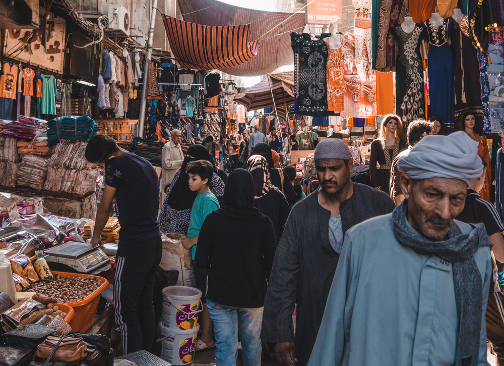 A group of people walk through a busy market in Cairo, Egypt