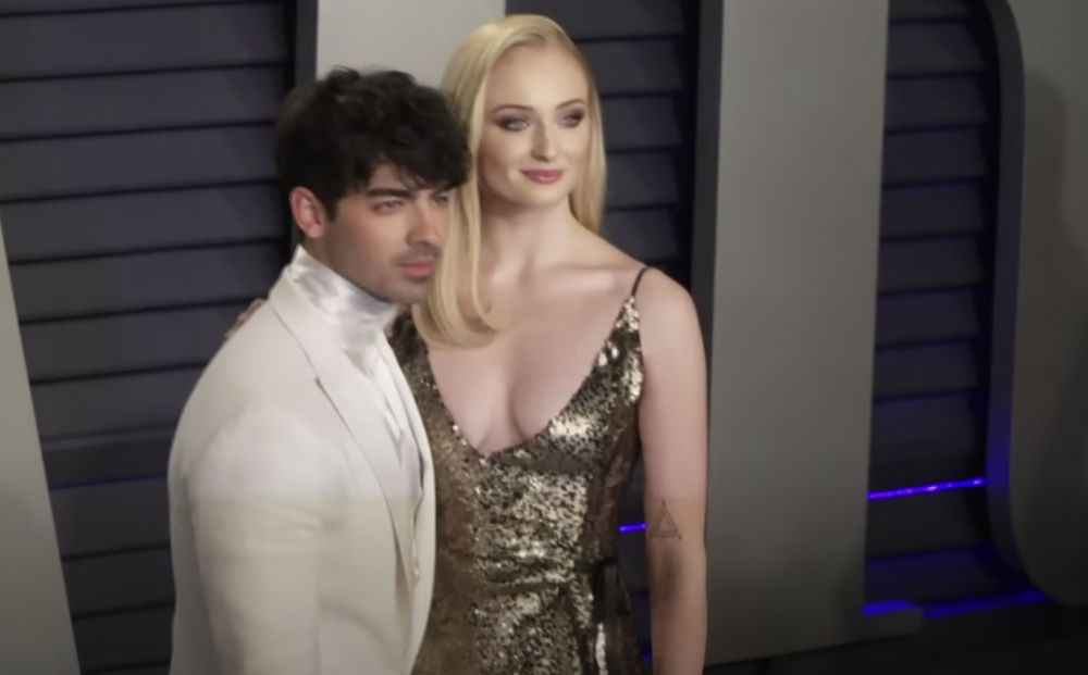 Joe Jonas in white tux and Sophie Turner in golden dress standing together