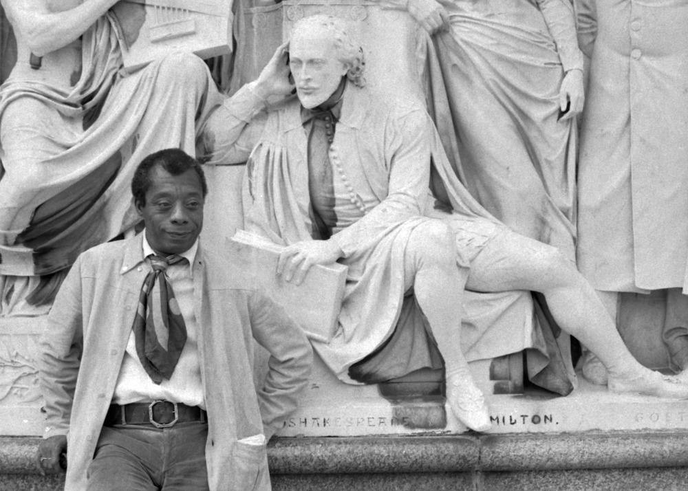 James Baldwin stands near a statue of William Shakespeare at the Albert Memorial