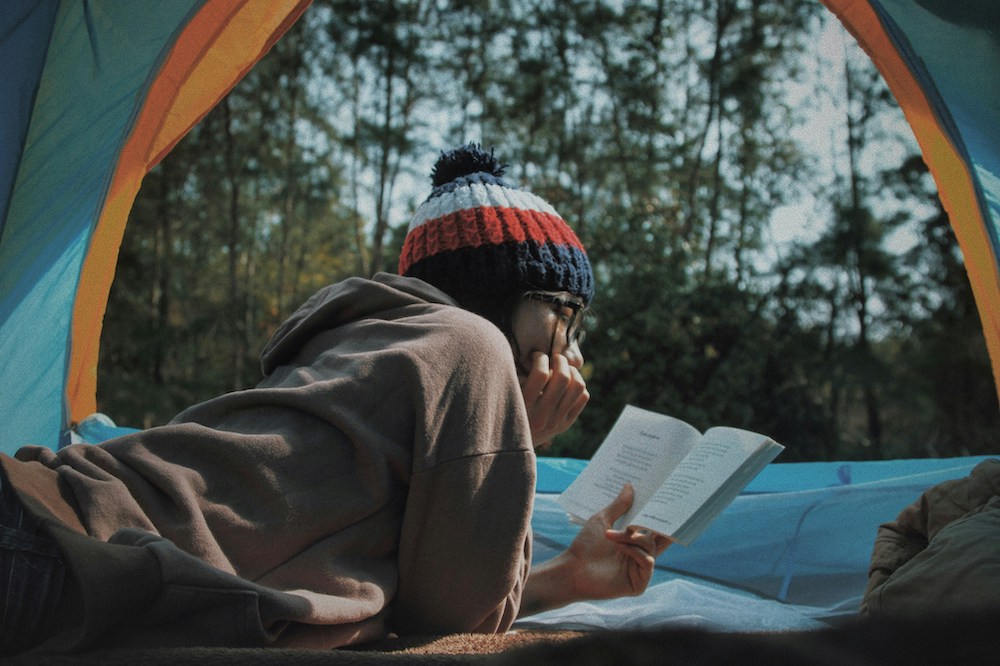 Person reading in tent