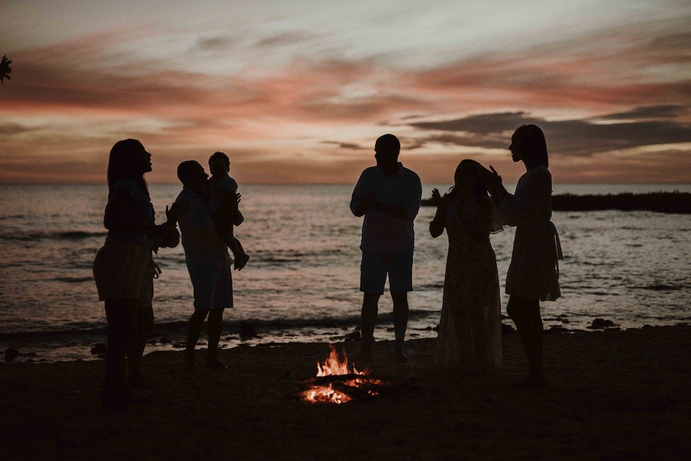 Group of people surrounding a campfire on a Dominican Republic beach