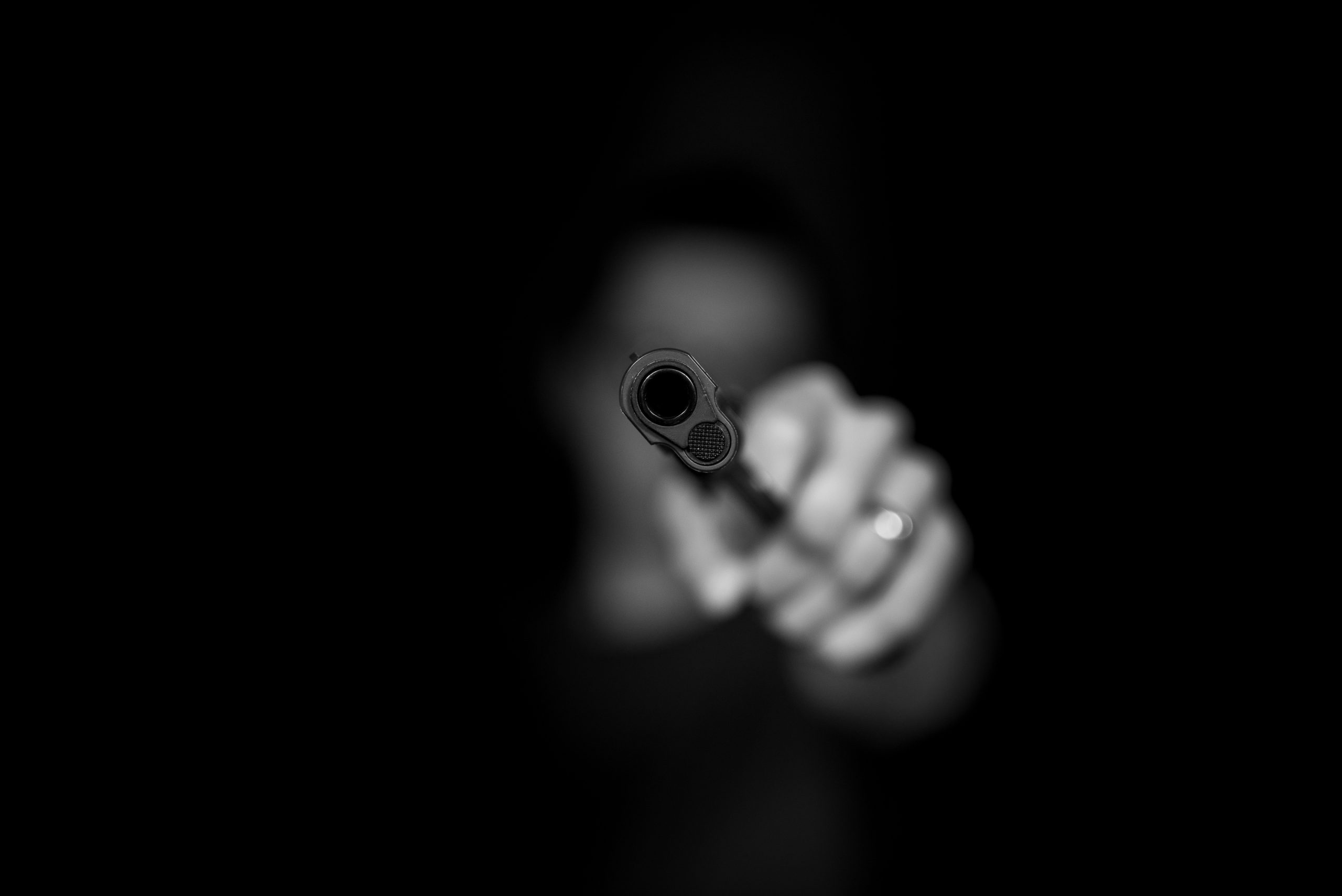 A black-and-white image of a person holding a gun