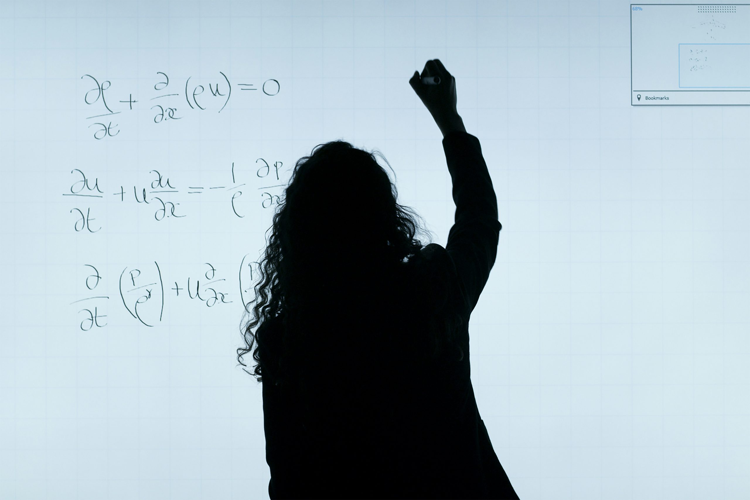 A woman writing equations on a board