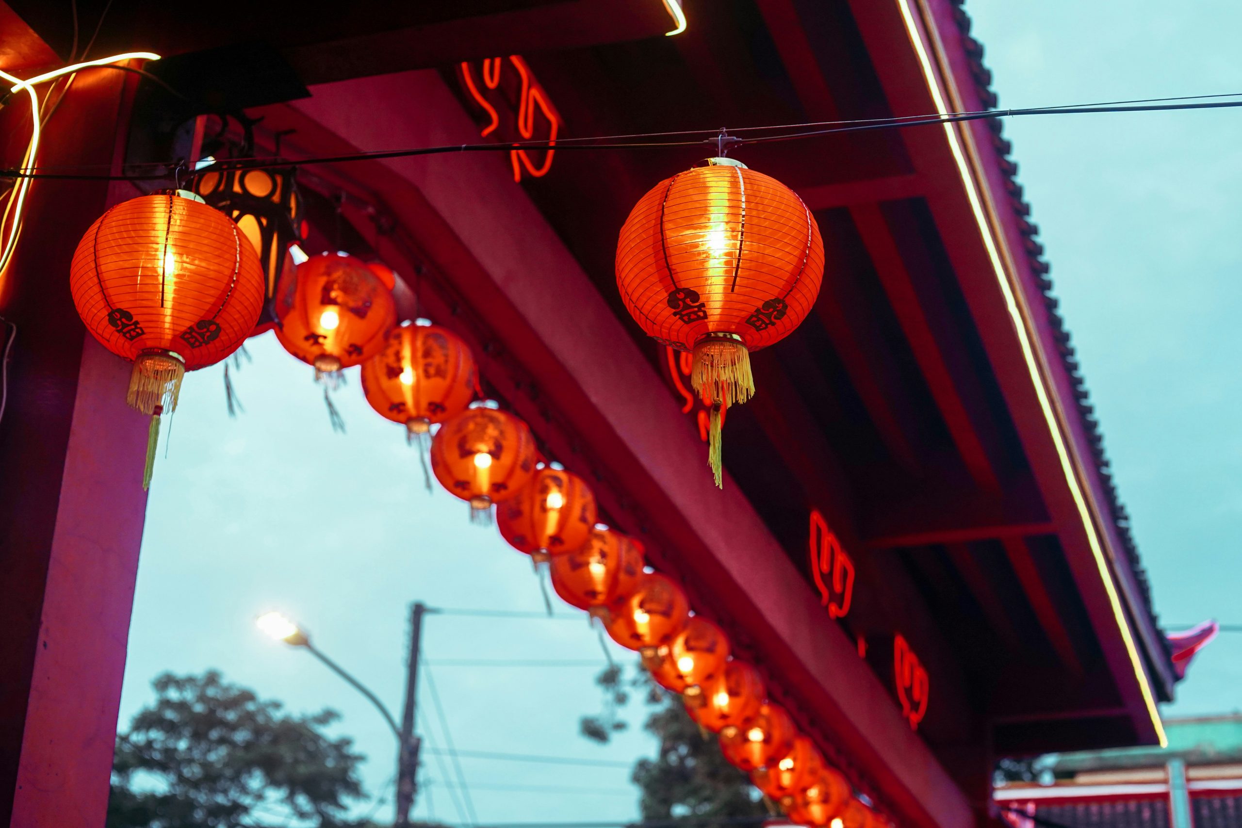 A group of red lanterns hanging from a roof